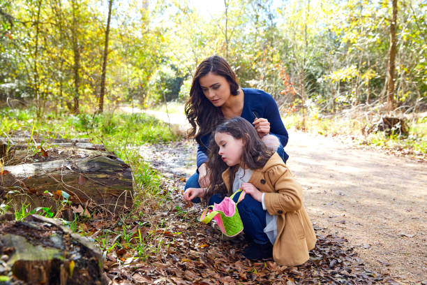 istock Mother daughter in a park picking clover plants 1335677008
