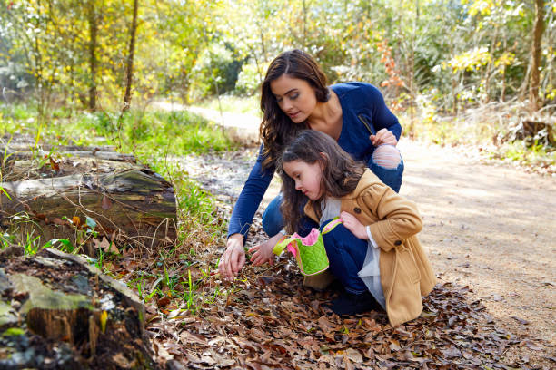 istock Mother daughter in a park picking clover plants 1335677093