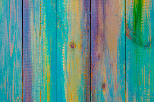 Wooden colored boards abstract background. The texture of the tree. Multi-colored festive backdrop made of natural materials.