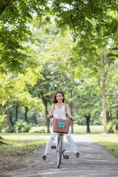 istock Smiling woman legs up riding bike in spring park 1335683071