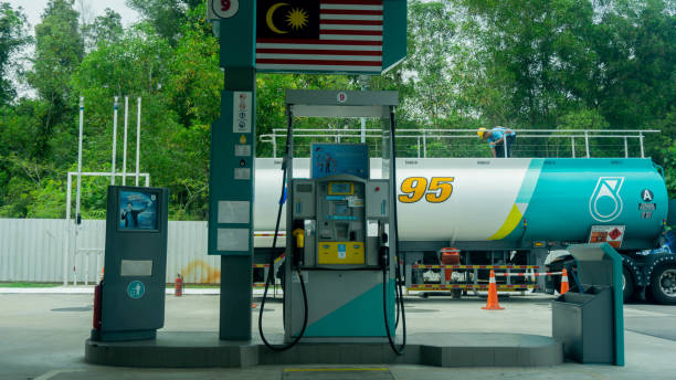 The Petronas petrol pump gas station. Sungai Buloh, Malaysia - December 28, 2019: The Petronas petrol pump gas station with the oil tank truck fill the oil in the underground storage at the background. twin towers malaysia stock pictures, royalty-free photos & images