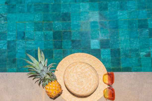 istock Hat, pineapple, glasses by the pool. Summer vacation concept 1335690409