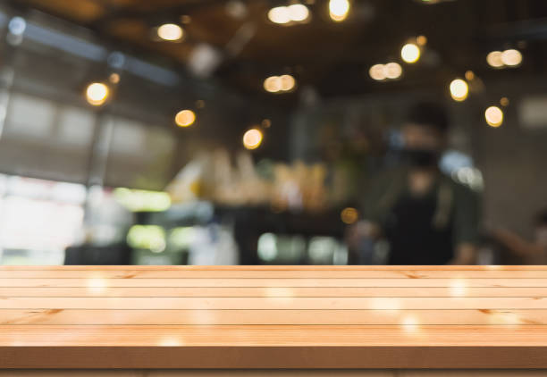 istock Empty wooden table top with lights bokeh on blur restaurant background. 1335695426