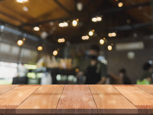 istock Empty wooden table top with lights bokeh on blur restaurant background. 1335695432