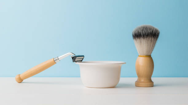 カミソリと木製のハンドルと白いテーブルの上の泡ボウル付きのブラシ。 - shaving equipment wash bowl bathroom razor ストックフォトと画像