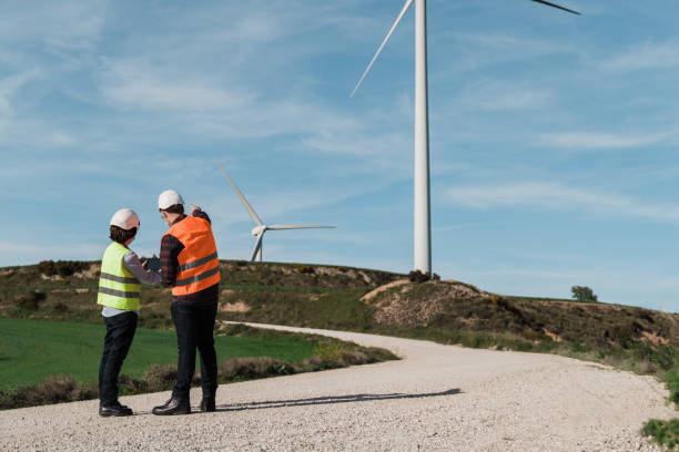 istock Engineer people using tablet at alternative energy wind green farm station wearing safety masks - Innovation and green power concept 1335696531