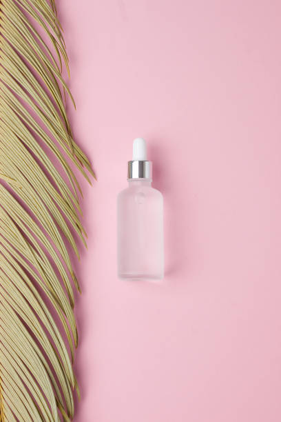 istock Cosmetic bottle with palm leaf on pink background. Flat lay 1335698643