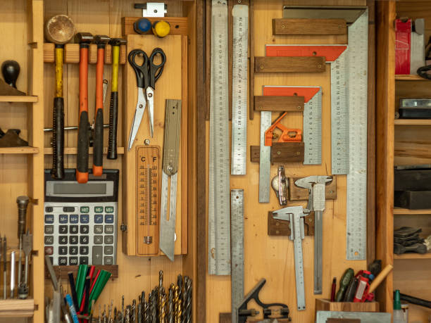 istock Carpenter's workshop. Various tools hang on a wooden wall. 1335699290