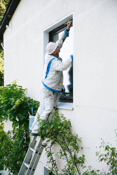 istock House painter paints the window frame from the outside 1335701187