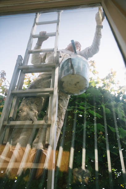 istock House painter paints the window frame from the outside 1335701191