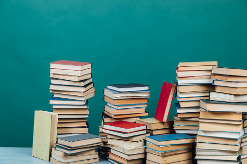 Pilas de libros para la enseñanza de la biblioteca de la universidad de conocimiento fondo verde photo