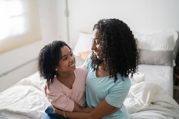 istock Happy sisters smiling and looking at each other at home 1335708947