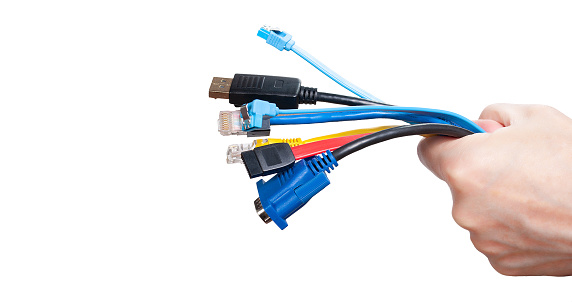 Bunch of computer cables in women's hand isolated on white background. Bundle of computer interface cables with different connectors