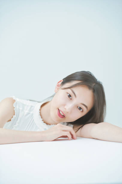 istock Young woman posing leaning against a white table 1335712653