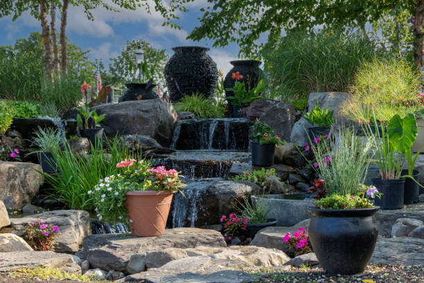 istock Waterscape fountain urns create a beautiful tranquil backyard oasis surrounded by bright pink and red flowers and ornamental grasses 1335712702