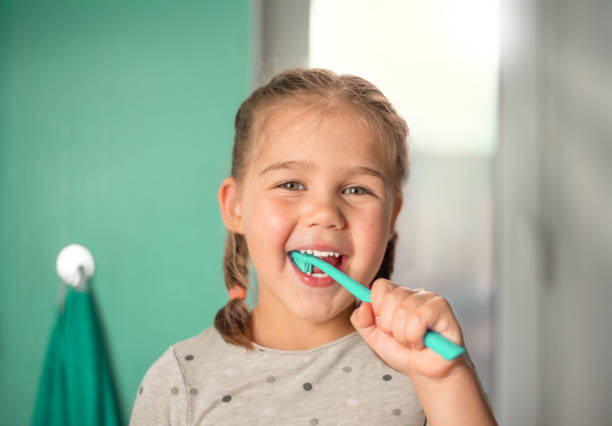 istock little girl brushing teeth in the bathroom 1335712932