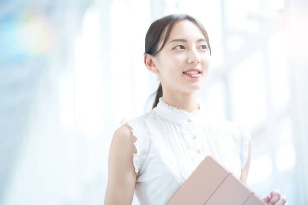 Young business woman or female college student Young business woman or female college student by the window japanese woman stock pictures, royalty-free photos & images