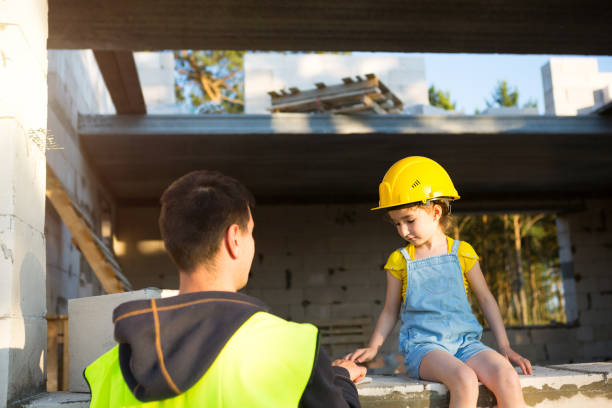 papá e hija están en el sitio de construcción de su futuro hogar. la elección de la futura profesión de constructor es heredada por el niño. la expectativa de mudarse, el sueño de una casa. hipoteca, préstamo - action family photograph fathers day fotografías e imágenes de stock