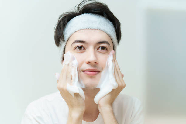 young man washing his face - gezicht wassen stockfoto's en -beelden
