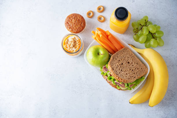 almoço saudável na escola com sanduíche, frutas frescas e suco - autumn banana breakfast close up - fotografias e filmes do acervo