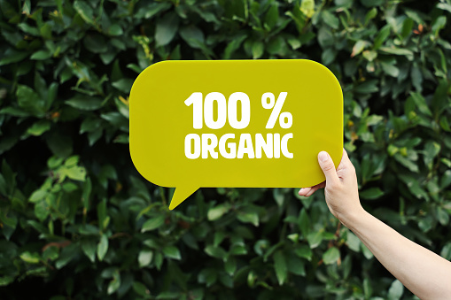 Hand holding speech bubble reads “Organic”