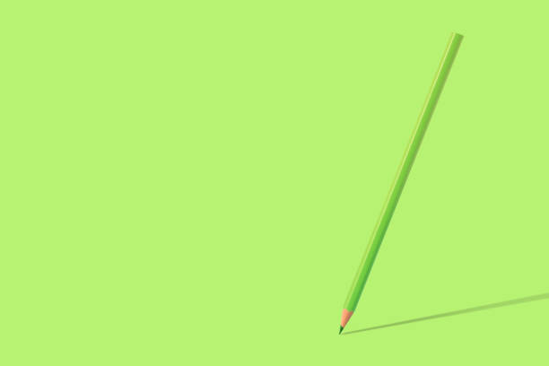 A green colored pencil standing on the green background with shadow and copy space