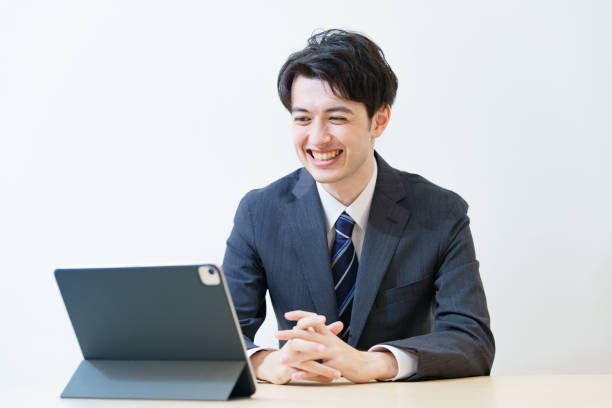 un homme en costume assistant à une réunion en ligne avec un regard détendu - internet student business men photos et images de collection
