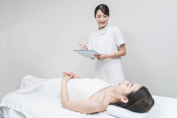 カウンセリングを受ける美容サロンの女性スタッフ - beauty treatment massaging beautician women ストックフォトと画像