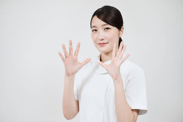 A woman in a white coat posing with her hands open