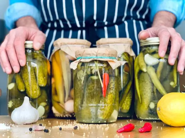 Artisanal: man is doing pickles jars stock for winter season. Organic homemade pickles