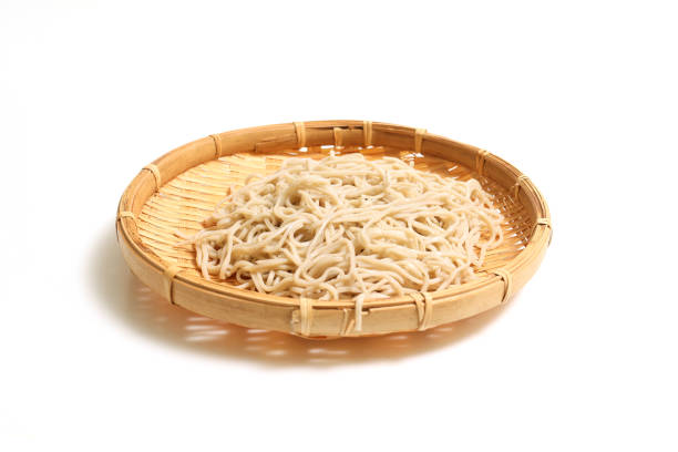 Buckwheat noodles on the bamboo colander isolated on a white background.