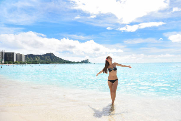 Happy beach woman in bikini on Waikiki Oahu Hawaii Happy beach woman in bikini joyful and free on Waikiki, Oahu, Hawaii, USA. Girl on travel vacation holidays having fun on Hawaiian Waikiki beach with Diamond Head mountain. Asian Caucasian model. swimwear bikini top bikini bikini bottom stock pictures, royalty-free photos & images