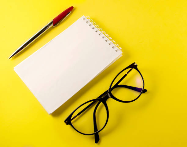 istock notepad, notebook, pen, glasses, on a yellow background, top view copy space 1335754437