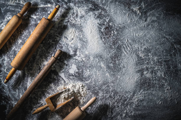 Rolling pin and flour serving scoop on flour spread background abstract for bakery themes