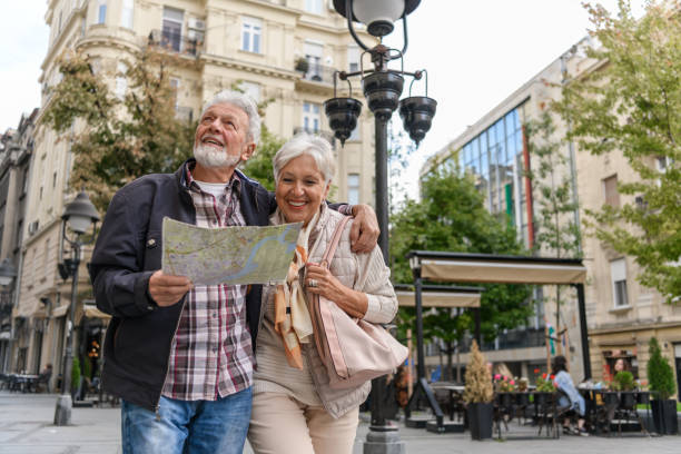 los viajeros mayores están haciendo turismo por la ciudad durante unas vacaciones utilizando un mapa de la ciudad. - couple mature adult europe travel fotografías e imágenes de stock