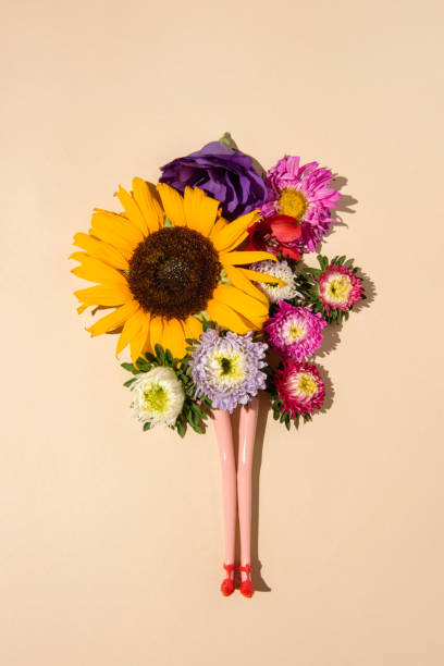 istock Doll legs with colorful spring flowers on pastel beige background. Flat lay. 1335761990
