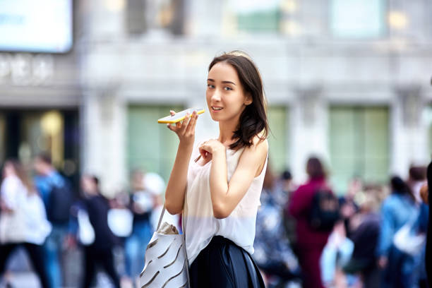 istock Graceful woman talks by smartphone while walking in city. 1335771023