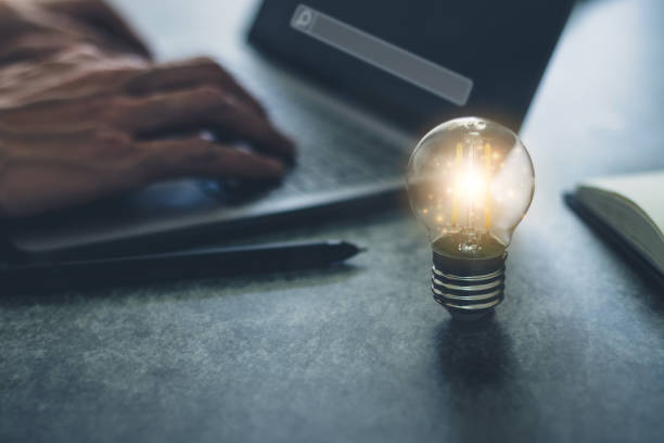 istock Bright light bulb with laptop and book. Business and education concept 1335772995