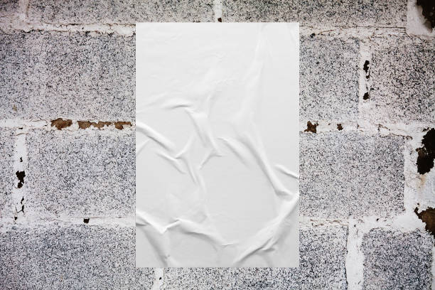 istock Blank white wheatpaste glued paper poster mockup on concrete wall background 1335774457
