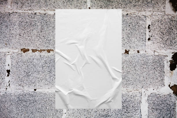 Blank white wheatpaste glued paper poster mockup on concrete wall background stock photo