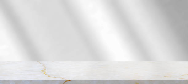 istock Marble table with window shadow drop on white wall background for mockup product display 1335774518