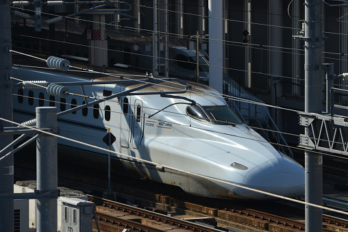 Japanese highspeed train on the tracks on a sunny day in Tokyo, Japan
