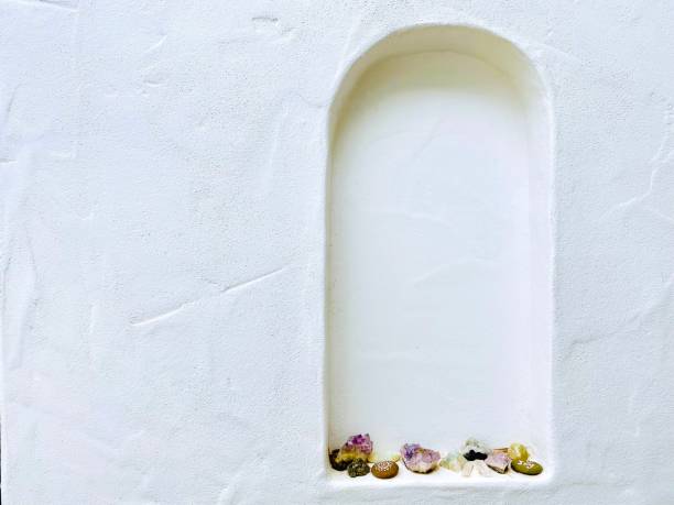White Alcove with Crystal Collection Horizontal closeup photo of a white painted textured wall with a collection of crystals on the ledge of an arched alcove in the wall alcove stock pictures, royalty-free photos & images