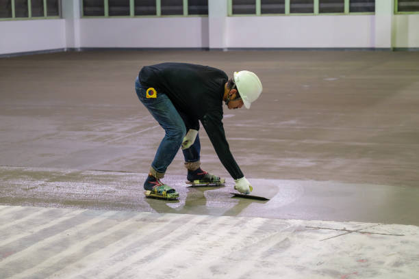 エポキシ床仕上げ作業の自己レベリング方法のための水分遮断エポキシプライマーを拡散するこてを使用した建設作業員 - paint roller ストックフォトと画像