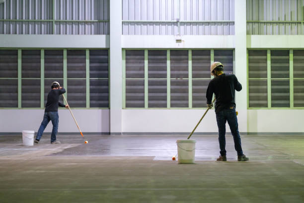 trabajador de la construcción que utiliza imprimación epoxi de dispersión de rollor para el método autonivelante de trabajos de acabado de pisos epoxi - envuelto fotografías e imágenes de stock