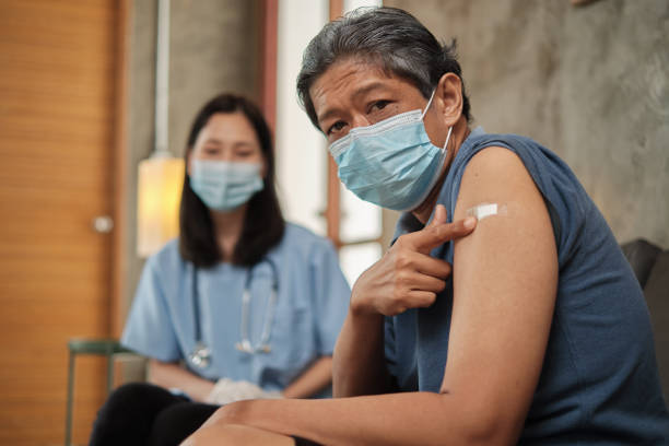istock Elderly patient points finger at arm after vaccinating. 1335792827