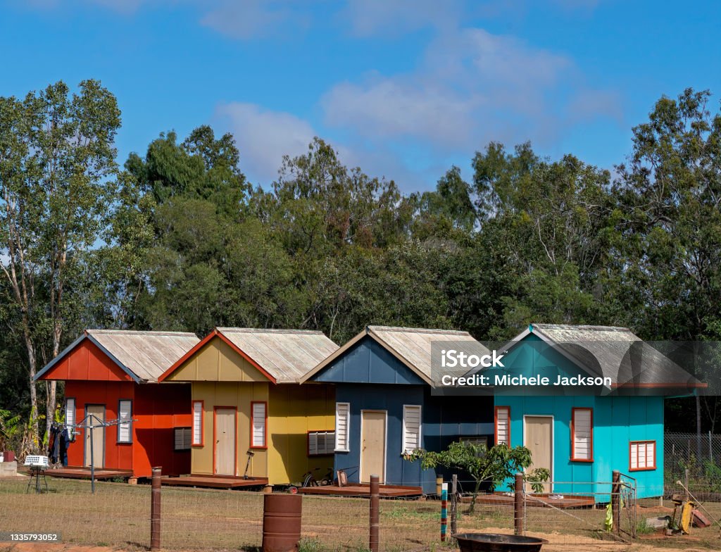 Tiny Homes A row of colorful tiny houses in a rural area, each with their own front door and small porch deck Tiny House Stock Photo