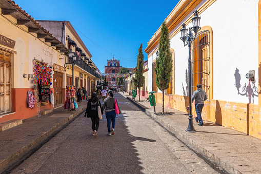 People walking in a colorful mexican colonial style street of downtown San Cristobal de las Casas, Chiapas state, Mexico.