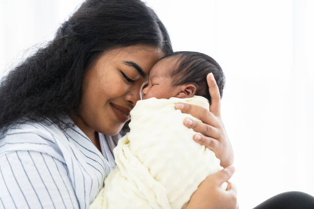 closeup of happy mother carrying and kissing her newborn baby - mother baby new kissing imagens e fotografias de stock