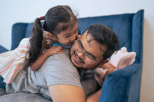 istock Kid kidding with father on sofa 1335795960